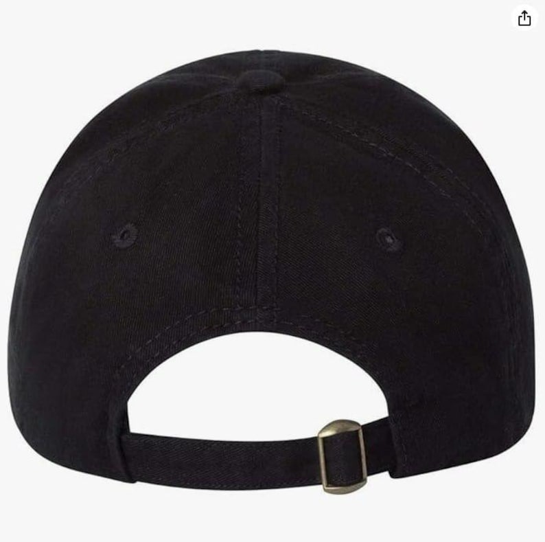 May include: Black baseball cap with a curved brim and adjustable strap. The cap features a metal buckle closure on the back for a secure fit. The hat is made of a solid black fabric.
