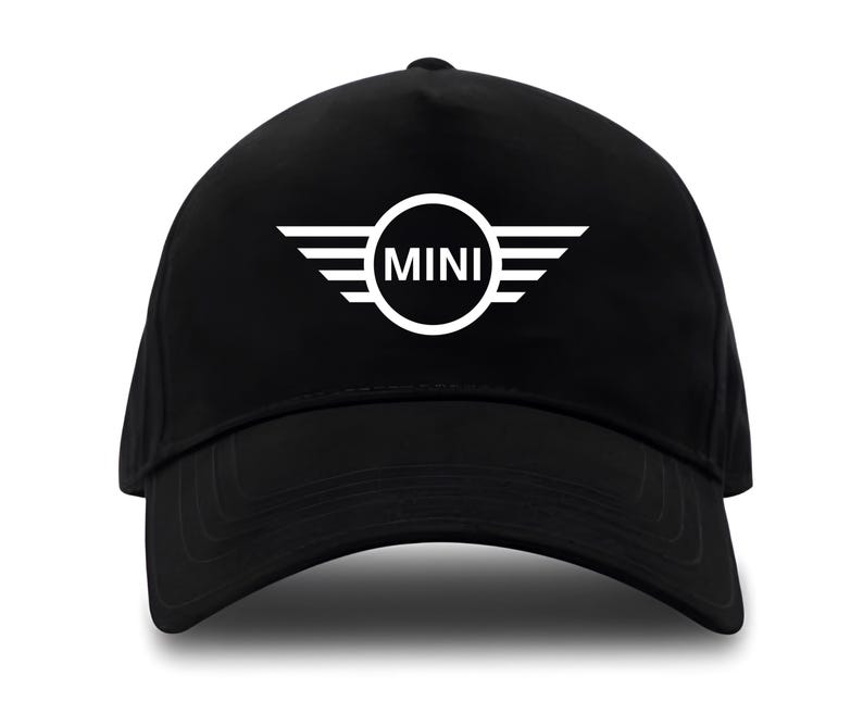 May include: Black baseball cap featuring the white "MINI" logo. The logo is a circle with the word "MINI" inside, flanked by white wings. The cap has a curved brim and a structured crown.