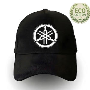 Peut inclure: Casquette de baseball noire avec le logo blanc Yamaha. La casquette a une visière incurvée et une couronne structurée. Un emblème "Eco Cotton" est visible à droite. Un accessoire de mode pour les fans de la marque.