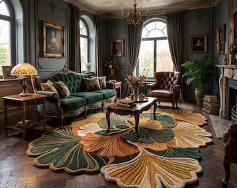 May include: A large, irregularly shaped area rug featuring a layered ginkgo leaf pattern in shades of deep green, mustard yellow, and burnt orange, placed on a dark wood herringbone floor in a room with a green velvet sofa and leather chair.