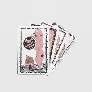 Pode incluir: Um conjunto de cartas de jogar ilustradas com um esquema de cores rosa e preto. Cada carta apresenta obras de arte &uacute;nicas, incluindo uma figura, um planeta e designs abstratos. As cartas est&atilde;o dispostas em leque.