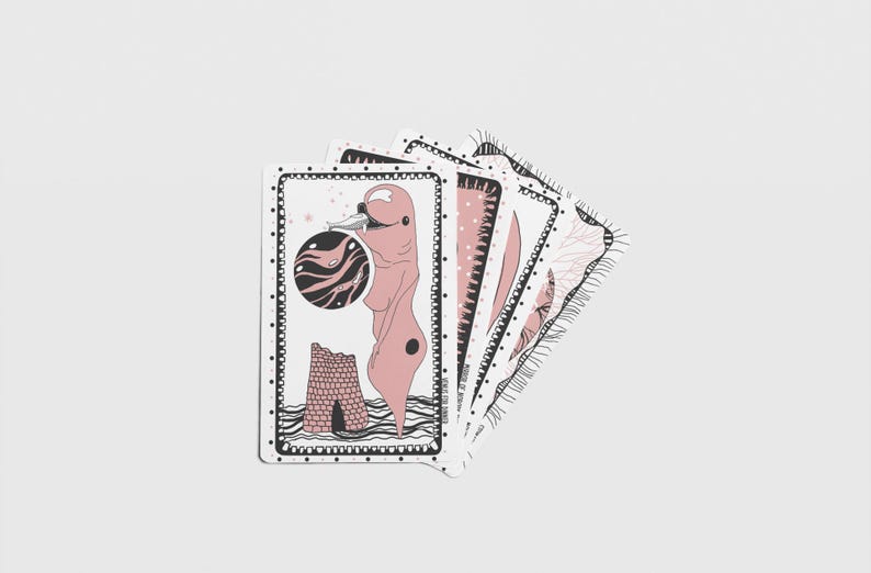 Pode incluir: Um conjunto de cartas de jogar ilustradas com um esquema de cores rosa e preto. Cada carta apresenta obras de arte &uacute;nicas, incluindo uma figura, um planeta e designs abstratos. As cartas est&atilde;o dispostas em leque.