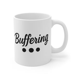 Könnte beinhalten: Weiße Keramik-Tasse mit dem Wort "Buffering" in schwarzer Schrift, darunter drei schwarze Punkte. Die Tasse hat einen gebogenen Henkel, ideal für Kaffee oder Tee.
