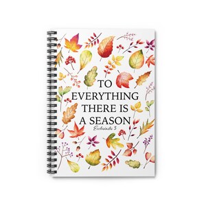 Può includere: Un quaderno a spirale con copertina bianca caratterizzato da un motivo ad acquerello di foglie autunnali e bacche colorate. Il testo al centro recita TO EVERYTHING THERE IS A SEASON Ecclesiastes 3 in caratteri serif e corsivi neri.