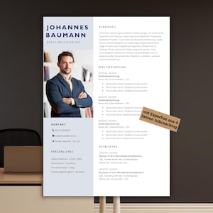 May include: A professional resume template with the name "Johannes Baumann" at the top. The resume includes sections for contact information, personal details, work experience, and education. A small wooden sign reads "mit Expertise aus 4 Jahren Jobcoaching".