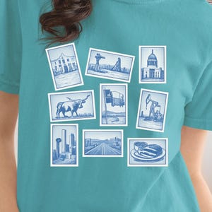 May include: Teal t-shirt featuring a collection of blue and white illustrations of various landmarks and objects. The shirt showcases a collage of images, including buildings, a bull, and a highway, creating a unique and artistic design.