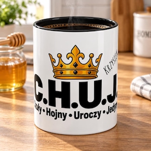 May include: A white ceramic mug with a black interior featuring a gold crown graphic above the bold black text C.H.U.J. and the name Krzysiek. Below the main text, the words Czuły, Hojny, Uroczy, and Jedyny are printed in black.