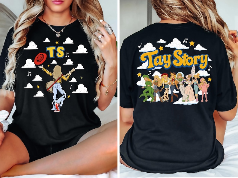 May include: A black t-shirt featuring a front graphic of a person with a guitar and the letters TS, and a back graphic with the text Tay Story above a group of illustrated characters in various outfits, all set against a background of white clouds.
