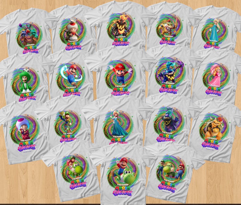 May include: A collection of white t-shirts featuring various Super Mario Galaxy character graphics. Each shirt displays a colorful, swirling cosmic background behind a specific character, with the Super Mario Galaxy logo printed below the artwork.