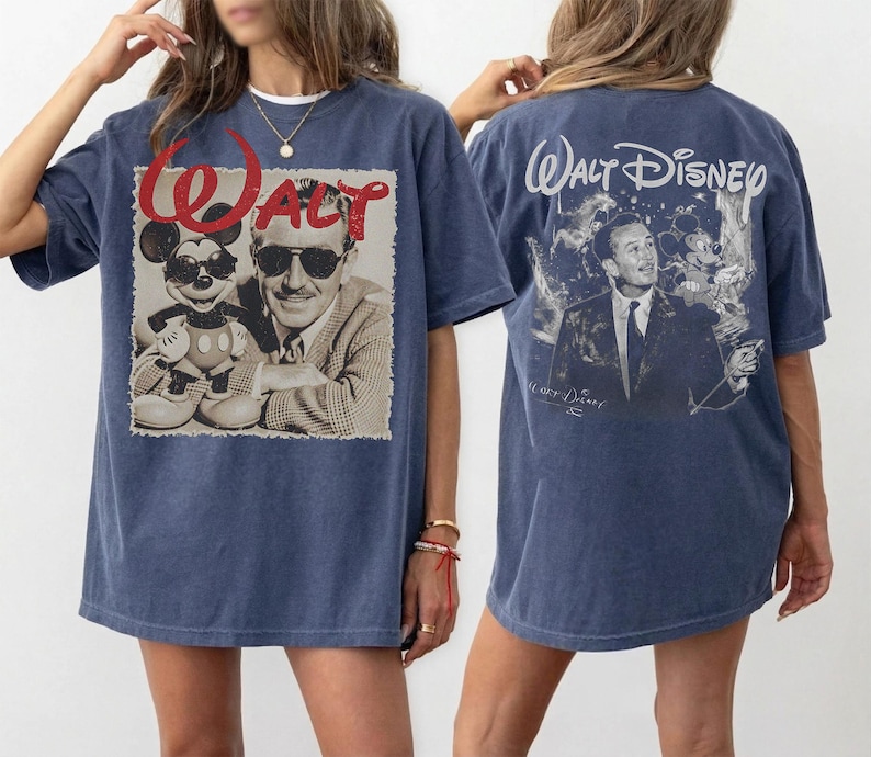 May include: A blue t-shirt featuring a graphic on the front of Walt Disney and Mickey Mouse wearing sunglasses with the red text WALT above them. The back of the t-shirt displays a graphic of Walt Disney with the text WALT DISNEY printed above.