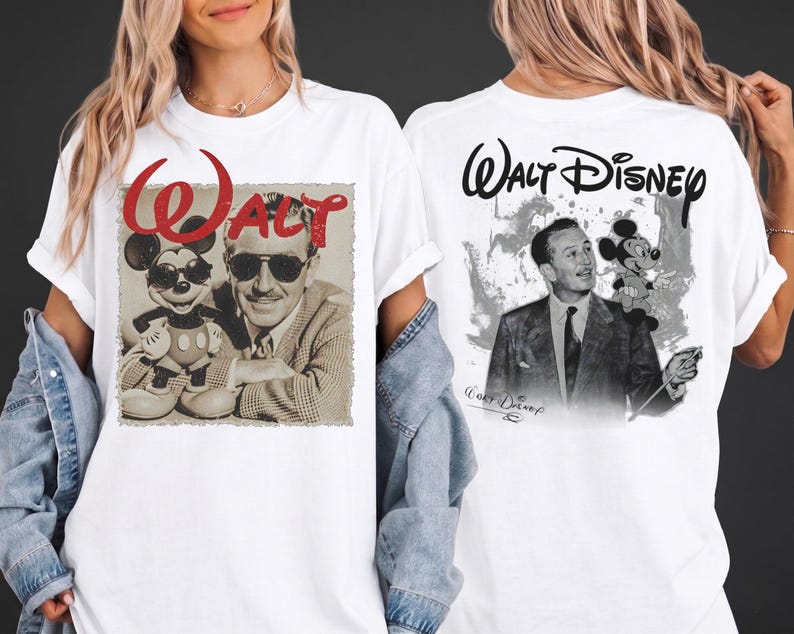 May include: A white t-shirt featuring a graphic print on the front and back. The front displays a black and white image of Walt Disney with Mickey Mouse, both wearing sunglasses, under the red text "WALT". The back shows Walt Disney with Mickey Mouse and the text "Walt Disney".