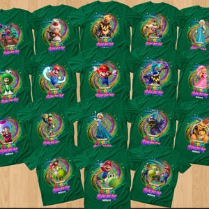 May include: A collection of fifteen dark green t-shirts, each featuring a unique character from The Super Mario Bros. Movie centered within a colorful, swirling cosmic graphic. The text The Super Mario Bros. Movie is printed below each character.