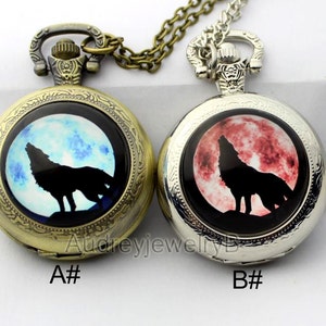 May include: Two antique silver pocket watches with chains. The watch faces feature a wolf howling at the moon. One watch has a blue moon and the other has a red moon. The watches are labelled A# and B#.