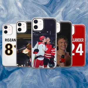May include: Five phone cases are displayed, each with a different image. One case has the name "ROZAN" and the number "8". Other cases feature portraits and hockey players. The cases are made of clear plastic.