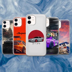 Op de afbeelding: Een verzameling telefoonhoesjes met auto-ontwerpen. De hoesjes tonen illustraties van verschillende auto's, waaronder een rode en oranje auto met een spoiler, een grijze auto met een rode cirkel en een paarse auto met tekst. De hoesjes staan op een rij.