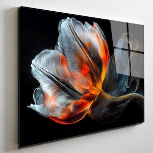 May include: A vibrant, artistic depiction of a flower against a black background. The flower features a blend of colors, including orange, white, and gray, with a hint of gold. The artwork is displayed on a glossy, rectangular surface.