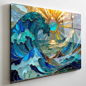 May include: Stained glass art piece depicting a seascape with a large wave, sun, and mountains. The artwork features shades of blue, teal, and gold, with a bright yellow sun. The piece is framed and mounted on a white wall.