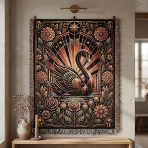 May include: A decorative tapestry featuring a stylized black swan against a geometric background of orange and black. The artwork is framed by floral and botanical elements in shades of brown, pink, and green. The tapestry has a fringed edge.