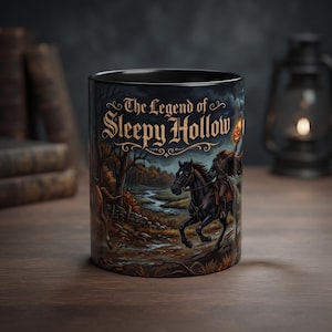 May include: A black ceramic mug featuring a graphic illustration of the Headless Horseman riding a black horse through a dark landscape. The text The Legend of Sleepy Hollow is printed in a decorative font at the top of the mug design.