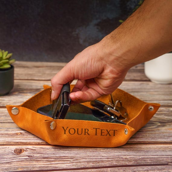 A hexagonal leather dice tray that doubles as a personalized valet — it's a dead giveaway that a real maker thought about tabletop gamers specifically, not just 'desk guys'.