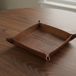 May include: A brown leather catchall tray with a diamond shape and stitched edges. The tray has the text "Two are better than one, because they have a good return for their labor. Ecclesiastes 4:"