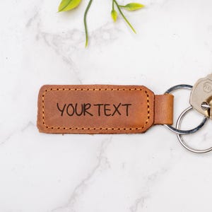 May include: A rustic wooden sign with the text "Welcome to our home" in white lettering. The sign features a distressed finish and a simple, inviting design, perfect for entryway decor.