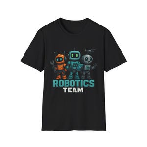 May include: Black t-shirt featuring a graphic of three robots in orange, teal, and gray. The robots are holding tools and a drone is above them. The text "ROBOTICS TEAM" is printed in teal and white below the robots.