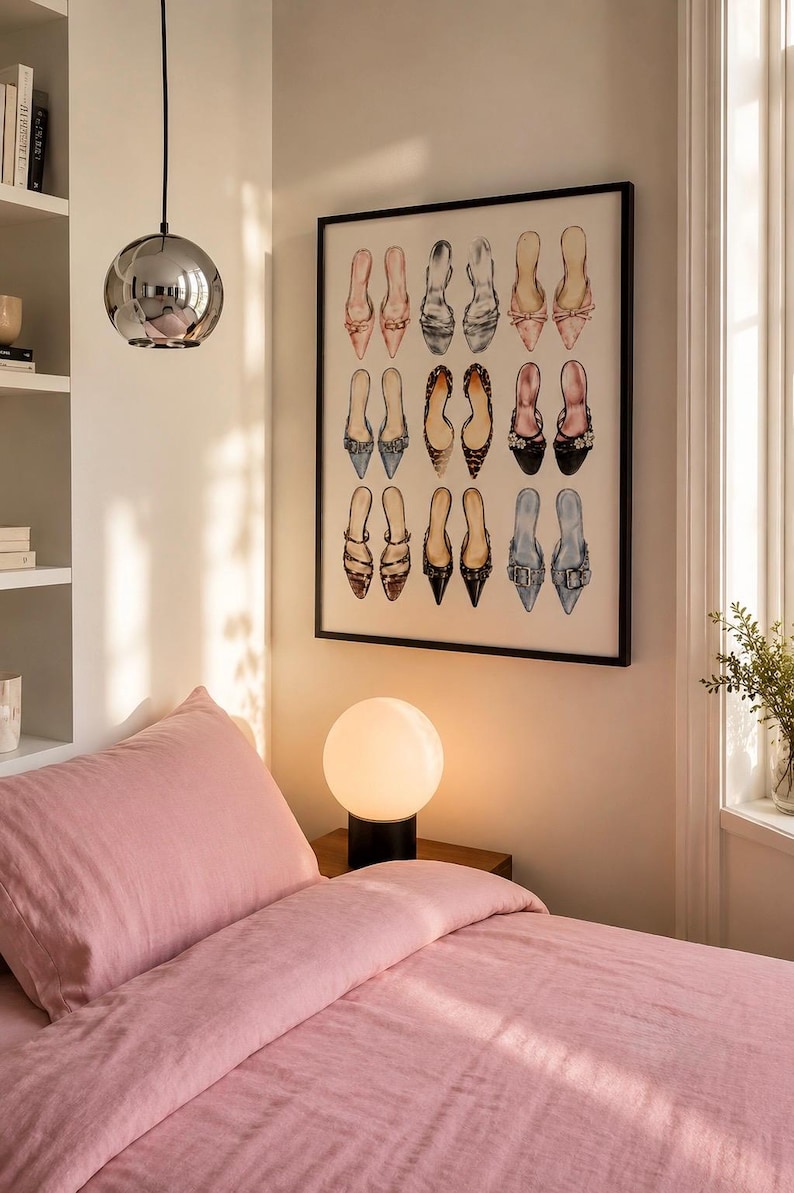May include: A framed wall art print featuring a grid of fifteen illustrated shoes in various colors and styles, including pointed-toe flats, heels, and mules in shades of pink, black, leopard print, and blue, displayed in a black frame.