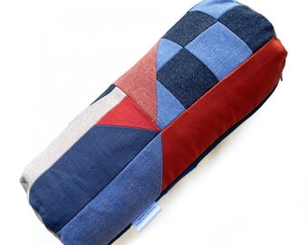 Geometric patterned checkerboard patchwork bolster cushion in reds and blues