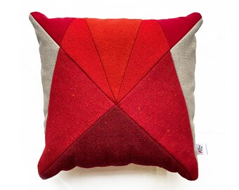 Geometric patterned  'AU' After Upholstery patchwork cushion in shades of red and cream