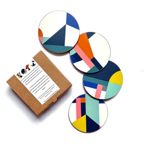 May include: Set of four colourful geometric coasters with a white background. The coasters feature a variety of shapes and colours, including blue, yellow, orange, pink, and green.