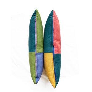 Peut inclure: Deux housses de coussin en patchwork vert, bleu, jaune et rose avec des fermetures &eacute;clair bleues.