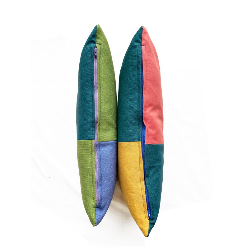 Peut inclure: Deux housses de coussin en patchwork vert, bleu, jaune et rose avec des fermetures &eacute;clair bleues.