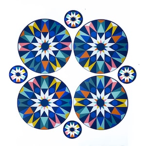 May include: Set of six blue, white, pink, and orange geometric patterned coasters. The coasters are round and feature a starburst design.