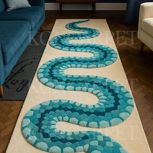 Könnte beinhalten: Ein beiger rechteckiger Teppich mit einem Design einer blau-türkisen Schlange. Der Schlangenkörper besteht aus geometrischen Formen in verschiedenen Blau- und Türkistönen. Der Schlangenkopf hat schwarze Augen und eine rosa Zunge. Der Teppich liegt auf einem Holzboden.