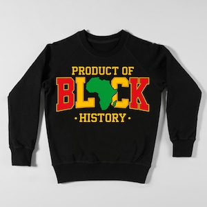May include: Black sweatshirt with the text "PRODUCT OF BLACK HISTORY" in yellow and red lettering. The word "BLACK" features a green outline of the African continent. The sweatshirt is a crew neck style.