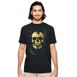 May include: Black t-shirt featuring a distressed gold skull graphic. The skull design has a vintage, weathered appearance. The shirt is a classic crew neck style.