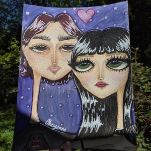 May include: A hand-drawn portrait of two figures with exaggerated features. The artwork features a purple background with white polka dots and a pink heart. The artist's name, "Cheyenne," is written on the artwork.