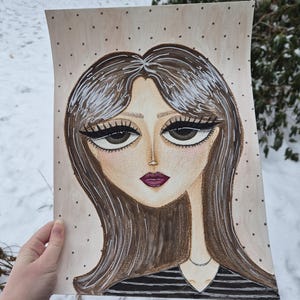 May include: A hand-drawn portrait of a woman with long brown hair and large eyes. The artwork features a black and white striped top and a delicate silver necklace. The background is a light beige with small, evenly spaced dark dots.