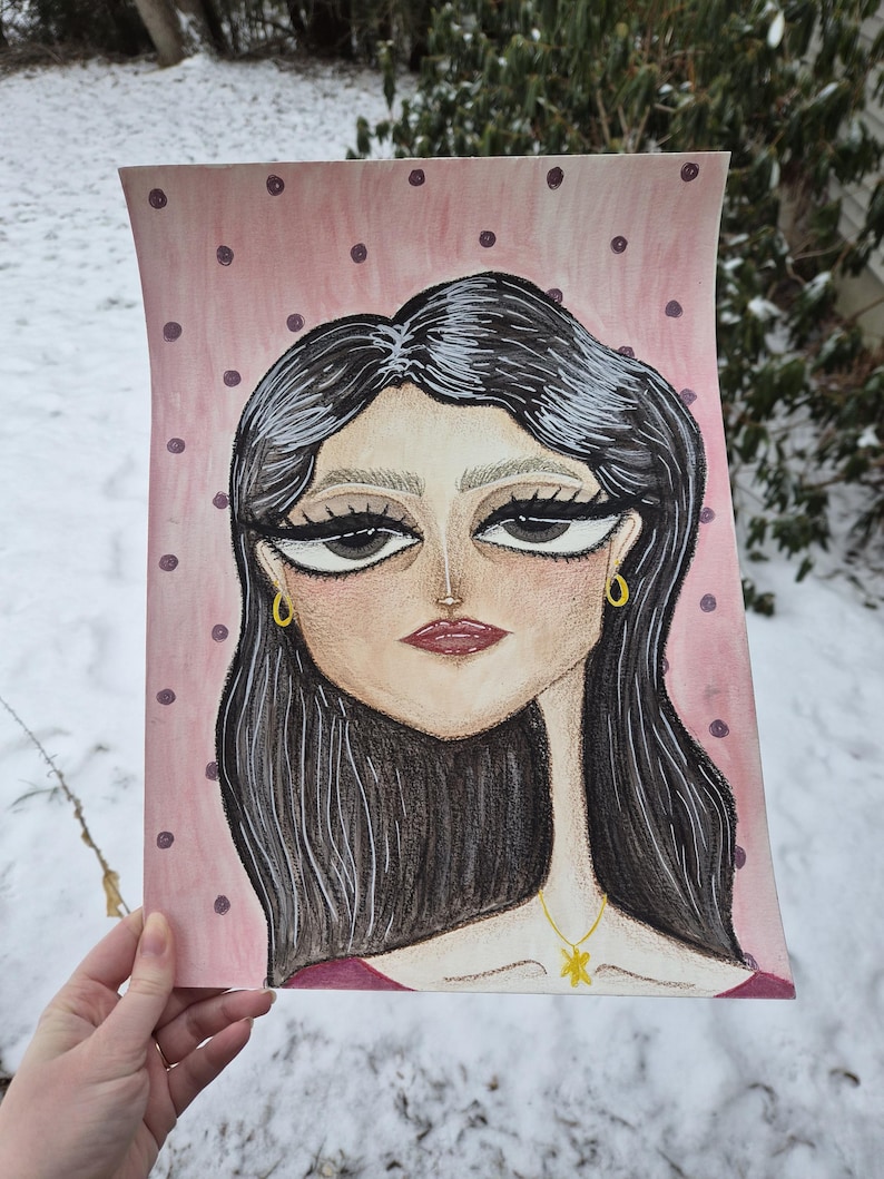 May include: A watercolor portrait of a woman with dark hair, large eyes, and a red lip. The background is pink with dark purple polka dots. The woman is wearing gold earrings and a gold pendant necklace.