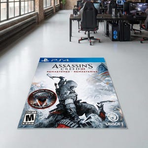 May include: A PS4 game case for Assassin's Creed III: Remastered. The cover art features a hooded figure with a bow and arrow, set against a snowy backdrop with an American flag. The game case is on a white floor in a large room.