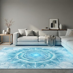 May include: A rectangular area rug with a blue and white floral design dominates the room. The rug's pattern resembles a glowing flower, with a bright blue center and radiating lines. The rug is placed in front of a light gray sectional sofa.