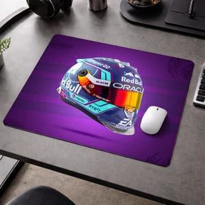 May include: A purple mousepad featuring a racing helmet design. The helmet is blue, red, and yellow, with sponsor logos. A white computer mouse sits to the right of the helmet.