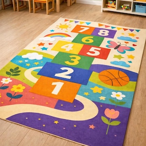 Può includere: Un colorato tappeto gioco della campana con i numeri da 1 a 8, un pallone da basket e illustrazioni di arcobaleno, sole, nuvole, fiori e una farfalla. Ideale per le aree gioco dei bambini.