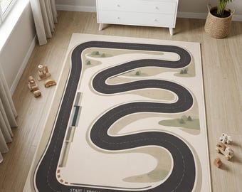 Op de afbeelding: Een rechthoekig vloerkleed met een kronkelend donkergrijs racebaandesign op een lichtbeige achtergrond. De baan bevat een start- en finishlijn, stippellijnen voor de rijstroken en kleine groene vlakken die het landschap voorstellen.