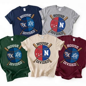 May include: Five t-shirts with baseball-themed designs. Each shirt features a baseball split into red and blue halves, with crossed bats and the text "HOUSE DIVIDED". The designs include letters and logos.