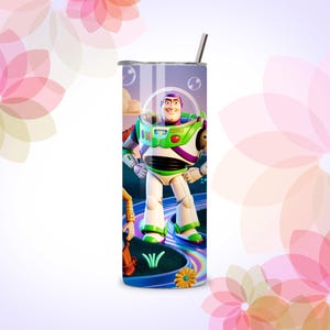 Może przedstawiać: Kubek ze stali nierdzewnej z kolorową grafiką Buzza Astrala z Toy Story. Projekt zawiera żywy obraz postaci w jego skafandrze kosmicznym, na tle kolorowej ścieżki i błękitnego nieba. Kubek ma srebrną pokrywkę i słomkę.