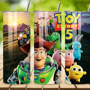 May include: A cylindrical tumbler featuring a Toy Story 5 graphic print. The design displays characters including Woody, Buzz Lightyear, Rex, Hamm, and Ducky and Bunny against a sunset landscape. The text Toy Story 5 is visible in bold yellow letters.