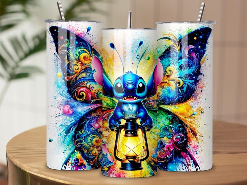 May include: Three white stainless steel tumblers with a colorful butterfly and Stitch design. The design features a blue cartoon character holding a lantern, set against a vibrant background of blues, yellows, and pinks. Each tumbler has a silver straw.