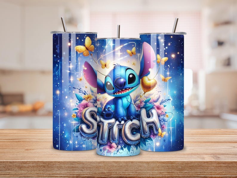 May include: Three blue tumblers with a whimsical design featuring the character Stitch, butterflies, and floral accents. The word "Stitch" is displayed in a bubble font. Each tumbler has a silver straw and a lid.